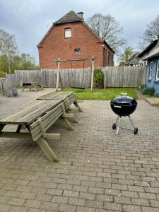 a barbecue grill next to a picnic table and a bench at Nørager Apartments in Nørager
