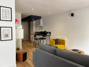 sala de estar con sofá gris y cocina en Détente et spa Expérience, en Villers-Allerand