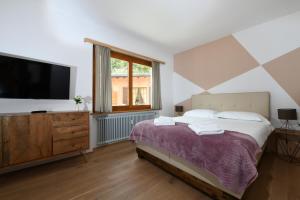 a bedroom with a large bed and a television at 7rooms Losone in Losone