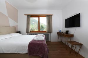 a bedroom with a bed and a flat screen tv at 7rooms Losone in Losone