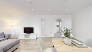 een witte woonkamer met een bank en een tafel bij Spacious three bedroom apartment with Valley views in Abertillery