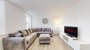 sala de estar con sofá y TV en Spacious three bedroom apartment with Valley views en Abertillery