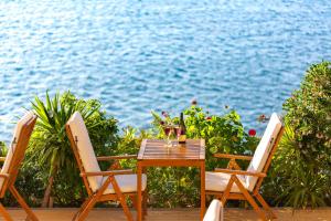 un tavolo e sedie su una terrazza vicino all'acqua di Sofia Ada a Fethiye