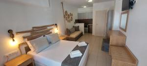 a living room with a large white bed in a room at Selinopetra Rooms in Elafonisos