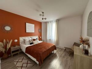 a bedroom with a large bed with orange walls at Beau Séjour in Épernay
