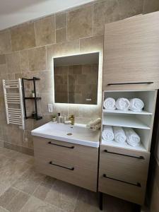 a bathroom with a sink and a mirror and towels at Beau Séjour in Épernay +38 photos