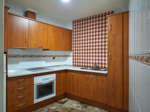 una cocina con armarios de madera y fregadero en Cazorla LIVE, en Cazorla