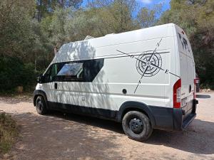 una furgoneta blanca estacionada al lado de una carretera en Furgoneta Camper Gran Volumen, en Palma de Mallorca