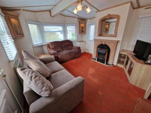 uma sala de estar com um sofá e uma lareira em Great Caravan With Spacious Decking Southview Holiday Park, Skegness Ref 33035v em Skegness