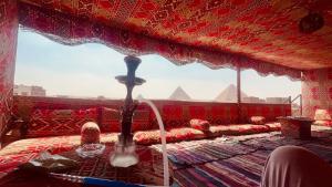 a room with a window with a view of the pyramids at king of pharaohs pyramids view in Cairo
