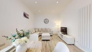 Sala de estar blanca con sofá y mesa en Spacious three bedroom apartment with Valley views en Abertillery