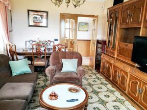 ein Wohnzimmer mit einem Sofa und einem Tisch in der Unterkunft 4 bedrooms house with terrace at Nois Lugo in Barrosa