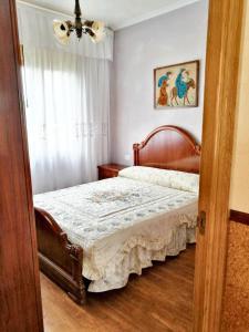 een slaapkamer met een bed met een houten hoofdeinde bij 4 bedrooms house with terrace at Nois Lugo in Barrosa