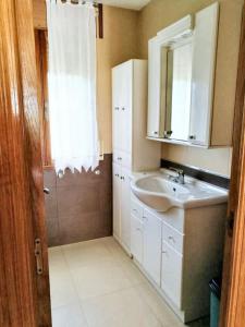 een badkamer met een wastafel en een spiegel bij 4 bedrooms house with terrace at Nois Lugo in Barrosa
