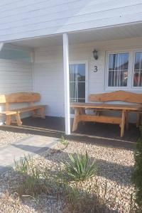 two picnic benches on the porch of a house at Domki Scandinavia in Rowy