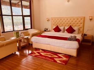 een slaapkamer met een groot bed met rode kussens bij Shewata Cottage in Kasol