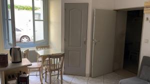 eine Küche mit einem Tisch, Stühlen und einer Tür in der Unterkunft Studio in the heart of historical house in Villeneuve-lès-Béziers