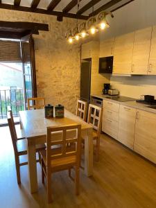 a kitchen with a wooden table and wooden chairs at La Casona de 1717 in El Burgo de Osma