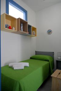 Zimmer mit 2 Betten, grüner Bettwäsche und einem Fenster in der Unterkunft Appartamento Dreaming Avola in Avola