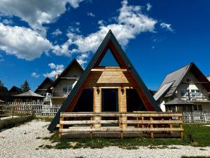 eine Hütte mit einem dreieckigen Dach am Strand in der Unterkunft Lacky in Vlasic