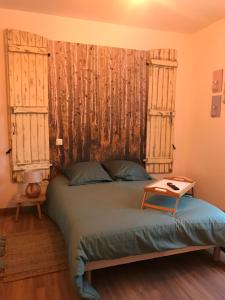 Un dormitorio con una cama grande con dos ventanas. en Balade en forêt, en Saint-Dizier