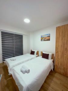 2 Betten in einem Zimmer mit weißer Bettwäsche in der Unterkunft Apartment Chloee in Gevgelija