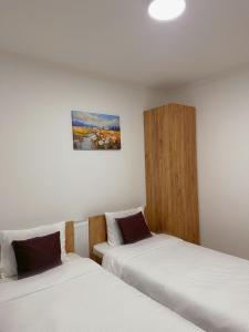 2 Betten in einem Zimmer mit weißer Bettwäsche in der Unterkunft Apartment Chloee in Gevgelija