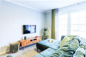 a living room with a couch and a tv at Birkenstraße 6 Haus II Whg5 in Zingst