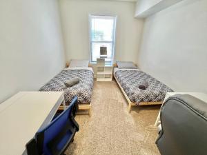 a room with two beds and a table and a window at 117-Three Bedroom 2 Bathroom Apartment Near NYC in Hoboken