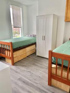 1 dormitorio con 2 camas, armario y ventana en 408-Newly Renovated 3 Bed 2 Bath Apartment, en Hoboken