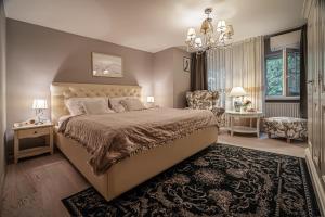 a bedroom with a large bed and a chandelier at Royal Bliss Apartment - Old Town with 2 bedrooms in Bratislava