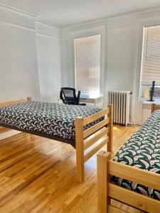 sypialnia z 2 łóżkami i krzesłem w obiekcie 411-Lovely Apt with Backyard near NYC Transit w mieście Hoboken