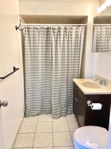 łazienka z zasłoną prysznicową i umywalką w obiekcie 411-Lovely Apt with Backyard near NYC Transit w mieście Hoboken