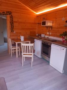a kitchen with a table and chairs in a cabin at Kilcavan Chalet in Gorey