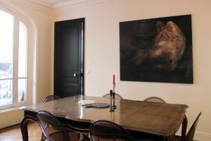 un comedor con una mesa y una pintura en la pared en Spacious luxury Haussmanian apartment, en París