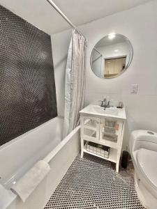 La salle de bains blanche est pourvue d'un lavabo et d'un miroir. dans l'établissement 0230-Central Cozy 2B 1B, à Hoboken