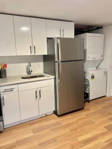 La cuisine est équipée de placards blancs et d'un réfrigérateur en acier inoxydable. dans l'établissement 0230-Central Cozy 2B 1B, à Hoboken