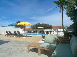 a patio with a couch and chairs and a pool at California Dream Inn in Aljezur