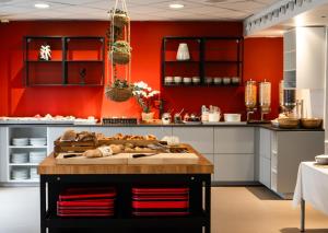 uma cozinha com paredes vermelhas e uma ilha numa cozinha em Good Morning City Copenhagen Star em Copenhague