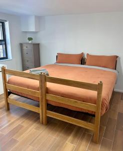 - une chambre dotée d'un grand lit avec des draps orange dans l'établissement 0230-Central Cozy 2B 1B, à Hoboken