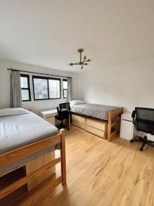 a bedroom with two beds and a desk and chairs at 232- 2B 2B Central Hoboken in Hoboken