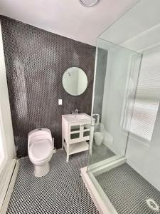 a bathroom with a toilet and a sink and a mirror at 232- 2B 2B Central Hoboken in Hoboken