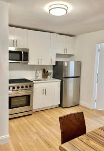 a kitchen with white cabinets and a stainless steel refrigerator at 232- 2B 2B Central Hoboken in Hoboken