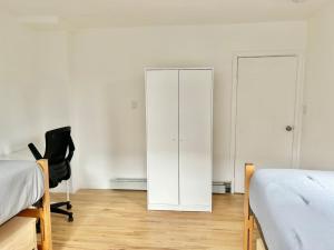 a bedroom with two beds and a white cabinet at 232- 2B 2B Central Hoboken in Hoboken