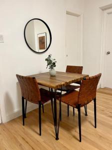 a dining room table with chairs and a mirror at 232- 2B 2B Central Hoboken in Hoboken