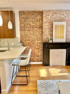 a kitchen with a brick wall and white chairs at 318-2 Bedroom 2 Bathroom Apt W In Unit Laundry in Hoboken