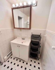 een badkamer met een witte wastafel en een spiegel bij 330- Unique Uptown W Lofted Bedrooms in Hoboken
