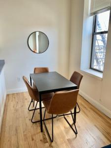 - une salle à manger avec une table, des chaises et un miroir dans l'établissement 222-Cozy Hoboken Apt on Main Street, à Hoboken
