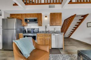 a kitchen with stainless steel appliances and wooden cabinets at Fall Creek Condo near The Strip! in Branson