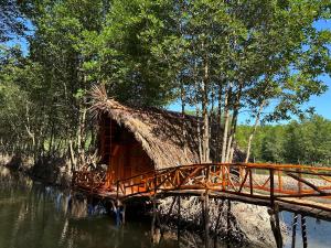 ein Gebäude mit einer Brücke in der Mitte eines Flusses in der Unterkunft FARMSTAY HOÀNG HÔN in Xóm Mũi
